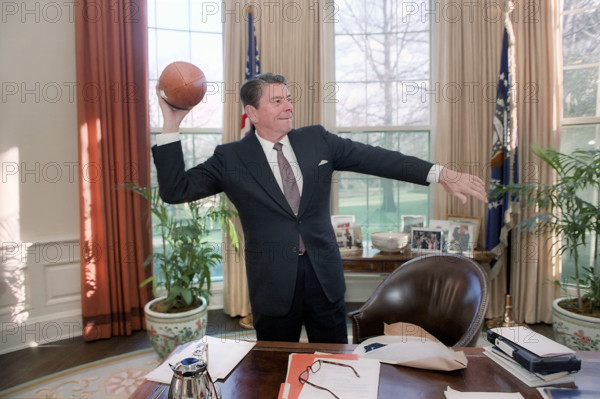 U.S. President Ronald Reagan throwing a USC football in the Oval Office of the White House, Washington, D.C., USA, President Ronald Reagan White House Photographic Office, March 26, 1982