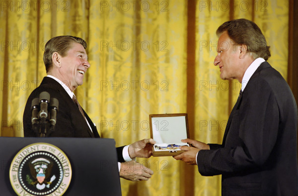 U.S. President Ronald Reagan presenting American evangelist Billy Graham in the East Room of the White House, Washington, D.C., USA, President Ronald Reagan White House Photographic Office, February 23, 1983