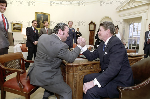 U.S. President Ronald Reagan arm wrestling Dan Lurie of Muscle Training magazine in Oval Office of the White House, Washington, D.C., USA, President Ronald Reagan White House Photographic Office, February 16, 1984