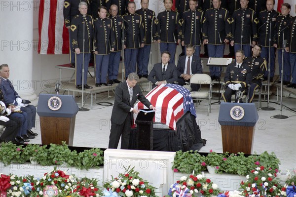 U.S. President Ronald Reagan presenting Congressional Medal of Honor before casket as Caspar Weinberger and John Ballantyne look on during Memorial day ceremony honoring the Vietnam Unknown Soldier, Arlington National Cemetery, Arlington, Virginia, USA, President Ronald Reagan White House Photographic Office, May 28, 1984