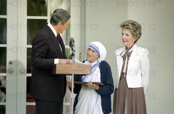 U.S. President Ronald Reagan presenting Mother Teresa with the Presidential Medal of Freedom as U.S. First Lady Nancy Reagan looks on  during White House Ceremony in the Rose Garden, White House, Washington, D.C., USA, President Ronald Reagan White House Photographic Office, June 10, 1985