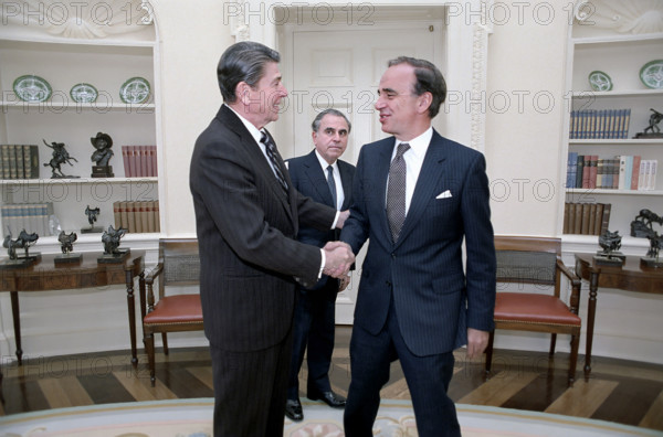 U.S. President Ronald Reagan shaking hands, with Rupert Murdoch as Director of U.S. Information Agency Charles Wick looks on during a meeting in the Oval Office of the White House, Washington, D.C., USA, President Ronald Reagan White House Photographic Office, January 18, 1983