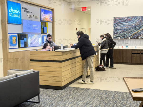 Customers being assisted at service counter, Charles Schwab & Company, Inc., 915 Broadway, Manhattan, New York City, New York, USA