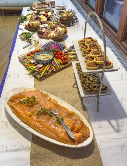 Charcuterie boards, savory tarts and plate of salmon on long table