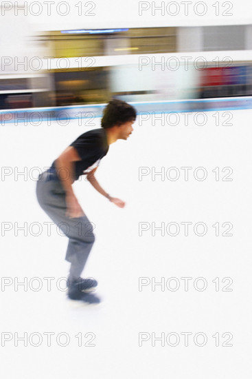 Young adult man ice skating at outdoor ice rink, blurred motion, Bryant Park, Manhattan, New York City, New York, USA