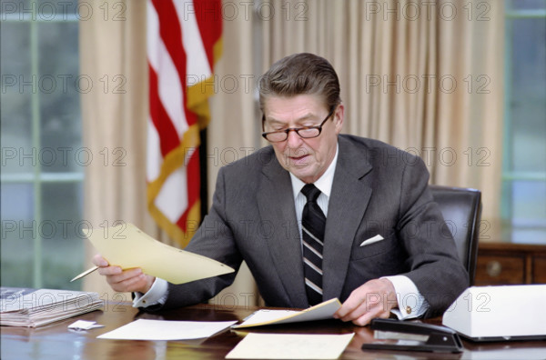 U.S. President Ronald Reagan on first day in administration in Oval Office, White House, Washington, D.C., USA, President Ronald Reagan White House Photographic Office, January 21, 1981