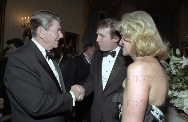 U.S. President Ronald Reagan shaking hands with Donald Trump and Ivana Trump during state visit of King Fahd of Saudi Arabia at the state dinner in the Blue Room of the White House, Washington, D.C., USA, President Ronald Reagan White House Photographic Office, February 11, 1985