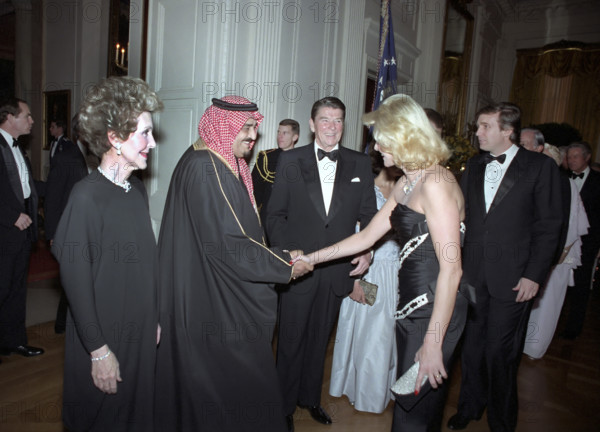 U.S. President Ronald Reagan, U.S. First Lady Nancy Reagan and Donald Trump looking on as Ivana Trump shakes hands with King Fahd of Saudi Arabia on receiving line at the state dinner in King Fahd's honor, East Room of the White House, Washington, D.C., USA, President Ronald Reagan White House Photographic Office, February 11, 1985