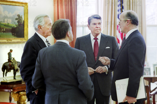 U.S. President Ronald Reagan (2nd right) meeting in the White House Oval Office with staff (L-R) Donald Regan, Caspar Weinberger and Admiral John Poindexter regarding the Libya air strike, Washington, D.C., USA, President Ronald Reagan White House Photographic Office, April 14, 1986