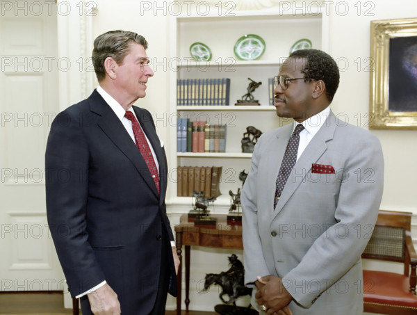U.S. President Ronald Reagan in the White House Oval Office during farewell photo opportunity with Clarence Thomas of The Equal Employment Opportunity Commission, Washington, D.C., USA, President Ronald Reagan White House Photographic Office, June 23, 1986