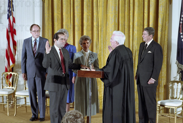 U.S. President Ronald Reagan watching swearing-In ceremony for Associate Justice Antonin Scalia by Chief Justice Warren Burger in the White House East Room, Washington, D.C., USA, President Ronald Reagan White House Photographic Office, September 26, 1986