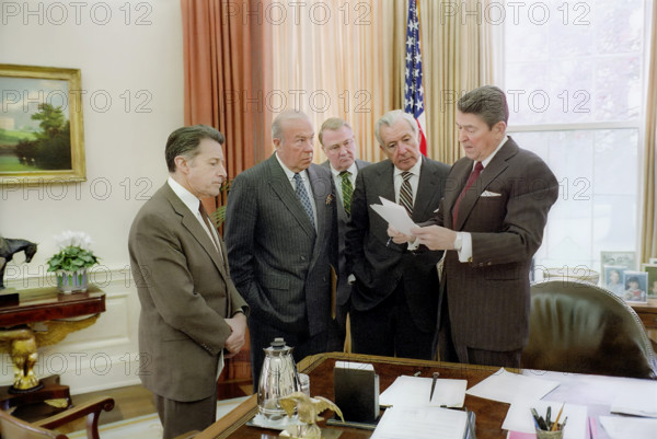 U.S. President Ronald Reagan with Caspar Weinberger, George Shultz, Edwin Meese and Donald  Regan in the White House Oval Office discussing the president's remarks on the Iran-Contra affair, Washington, D.C., USA, President Ronald Reagan White House Photographic Office, November 25, 1986
