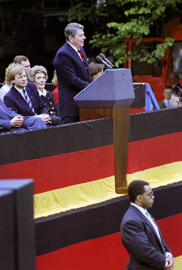 U.S. President Ronald Reagan giving remarks at Brandenburg Gate with U.S. First Lady Nancy Reagan and West Berlin mayor Eberhard Diepgen in background, West Berlin, Germany, President Ronald Reagan White House Photographic Office, June 12, 1987
