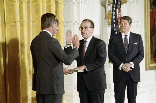 U.S. Vice President George H.W. Bush  swearing-In Alan Greenspan as Chairman of Federal Reserve Board as U.S. President Ronald Reagan looks on, White House East Room, Washington, D.C., USA, President Ronald Reagan White House Photographic Office, August 11, 1987