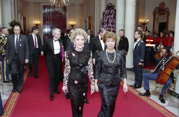 U.S. First Lady Nancy Reagan walking with First Lady of the Soviet Union Raisa Gorbachev in White House Cross Hall before State Dinner, Washington, D.C., USA, President Ronald Reagan White House Photographic Office, December 8, 1987