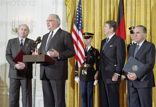U.S. President Ronald Reagan during a working visit of Chancellor Helmut Kohl of The Federal Republic of Germany and their exchanging departure remarks with Charles Wick and Harry Obst, White House East Room, Washington, D.C., USA, President Ronald Reagan White House Photographic Office, February 19, 1988,