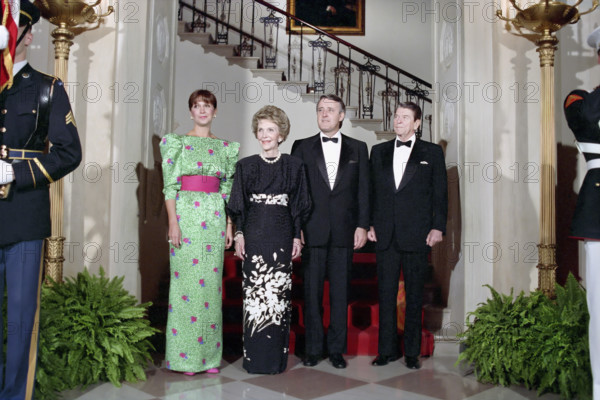 U.S. President Ronald Reagan (right), Prime Minister of Canada Brian Mulroney (2nd right), U.S. First Lady Nancy Reagan (2nd left) and Mila Mulroney (left) in White House Cross Hall before a state dinner, Washington, D.C., USA, President Ronald Reagan White House Photographic Office, April 27, 1988