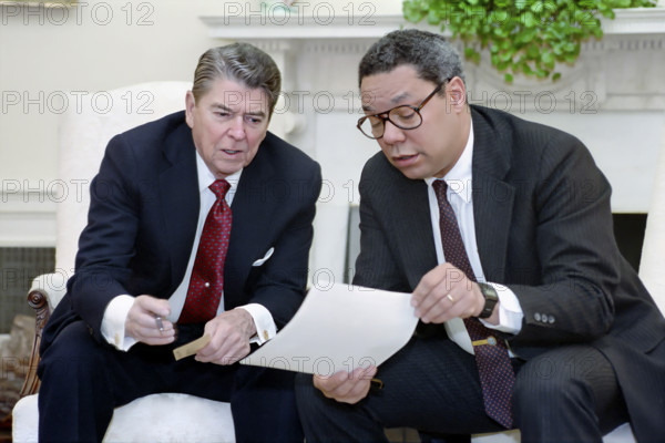 U.S. President Ronald Reagan holding a National Security Council meeting on the Persian Gulf with National Security Advisor Colin Powell, White House Oval Office, Washington, D.C., USA, President Ronald Reagan White House Photographic Office, April 18, 1988