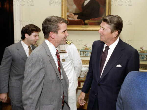 U.S. President Ronald Reagan greeting Oliver North during ceremony to present Medal of Freedom to Ambassador Philip Habib, White House Blue Room, Washington, D.C., USA, President Ronald Reagan White House Photographic Office, September 7, 1982