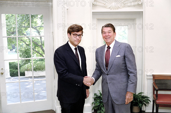 U.S. President Ronald Reagan and Deputy Assistant Director for Legal Policy William Barr shaking hands in White House Oval Office, Washington, D.C., USA, President Ronald Reagan White House Photographic Office, August 9, 1983