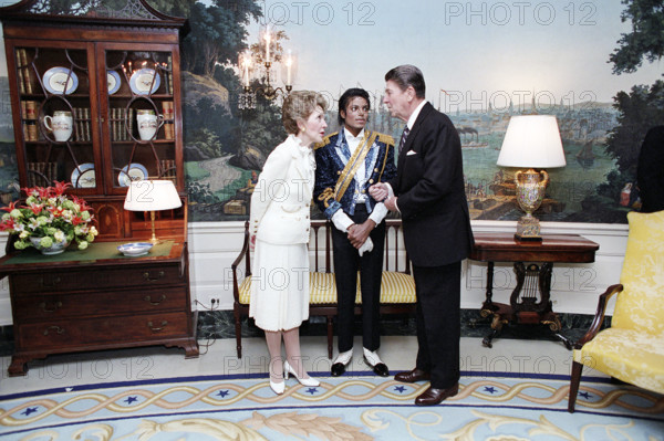 U.S. President Ronald Reagan talking to Nancy Reagan and Michael Jackson at ceremony to present plaque to Michael Jackson in recognition of his lifetime of achievement and personal efforts in aiding the National Campaign Against Drunk Driving, White House Diplomatic Reception Room, Washington, D.C., USA, President Ronald Reagan White House Photographic Office, May 14, 1984