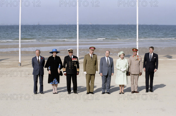 Canada Prime Minister Pierre Trudeau, Queen Beatrix of the Netherlands, King Olav V of Denmark, King Baudouin I of Belgium, President of France Francois Mitterrand, Queen Elizabeth II of Great Britain, Grand Duke Jean of Luxembourg and U.S. President Ronald Reagan attending 40th Anniversary of D-Day landings ceremony, Omaha Beach, Colleville-sur-Mer, France, President Ronald Reagan White House Photographic Office, June 6, 1984