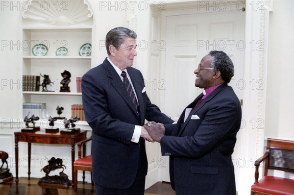 U.S. President Ronald Reagan meeting with Bishop Desmond Tutu of Anglican Church of South Africa, White House Oval Office, Washington, D.C., USA, President Ronald Reagan White House Photographic Office, December 7, 1984