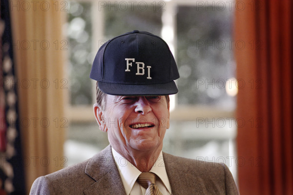 U.S. President Ronald Reagan wearing FBI baseball cap in White house Oval Office, Washington, D.C., USA, President Ronald Reagan White House Photographic Office, October 26, 1988