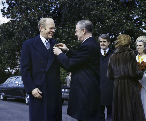 Prime Minister Liam Cosgrave of Ireland pinning shamrocks on U.S. President Gerald R. Ford's lapel in the White House South Driveway upon his arrival for a state visit, U.S. First Lady Betty Ford greeting Vera Cosgrove on right, Washington, D.C., USA, Gerald R. Ford White House Photographs, March 17, 1976