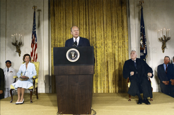 U.S. President Gerald R. Ford delivering remarks upon being sworn in as 38th President of the United States, U.S. First Lady Betty Ford sitting left, U.S. Supreme Court Chief Justice Warren Burger sitting right, White House East Room, Washington, D.C., USA, Gerald R. Ford White House Photographs, August 9, 1974