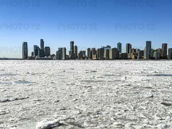 View of Jersey City, New Jersey, USA skyline across frozen Hudson River