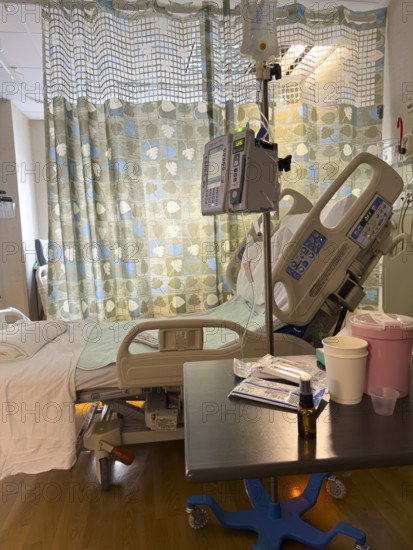 Empty hospital bed in patient room with medical equipment