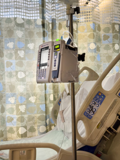 Empty hospital bed in patient room with medical equipment