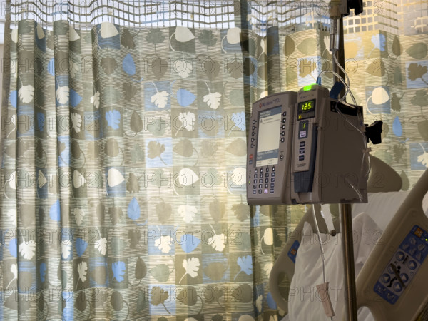 Empty hospital bed in patient room with medical equipment