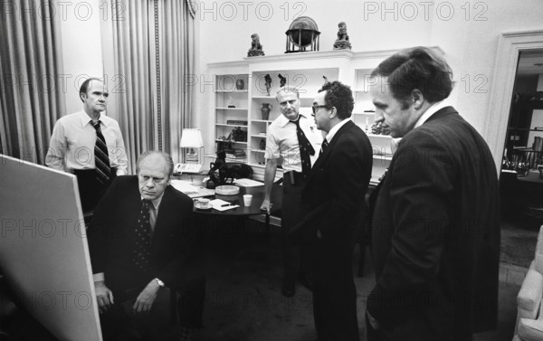 U.S. President Gerald R. Ford monitoring evacuation of American citizens from Beirut, Lebanon from the Office of National Security Adviser Brent Scowcroft (standing left) in early morning hours, also present are Counselor John Marsh, Deputy Assistant for National Security Affairs William G. Hyland and Chief of Staff Dick Cheney, Washington, D.C., USA, Gerald R. Ford White House Photographs, June 17,1976