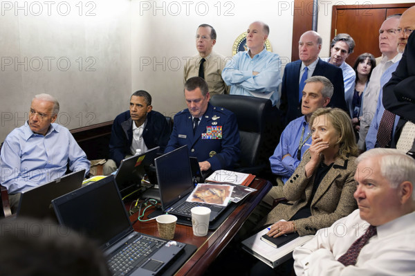 U.S. President Barack Obama and U.S. Vice President Joseph Biden, along with members of the national security team, receiving update on mission against Osama bin Laden in the White House  Situation Room, Seated, from left, are: Brigadier General Marshall B. (Brad) Webb, Assistant Commanding General, Joint Special Operations Command; Deputy National Security Advisor Denis McDonough; Secretary of State Hillary Rodham Clinton; and Secretary of Defense Robert Gates. Standing, from left, are: Admiral Mike Mullen, Chairman of the Joint Chiefs of Staff; National Security Advisor Tom Donilon; Chief of Staff Bill Daley; Tony Binken, National Security Advisor to the Vice President; Audrey Tomason Director for Counterterrorism; John Brennan, Assistant to the President for Homeland Security and Counterterrorism; and Director of National Intelligence James Clapper Washington, D.C., USA, Pete Souza, Office of White House Photography Office, May 1, 2011