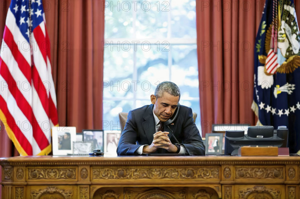 U.S. President Barack Obama talking on telephone with pastors who offer birthday prayer during call in White House Oval Office, Washington, D.C., USA, Pete Souza, Office of White House Photography, August 4, 2015
