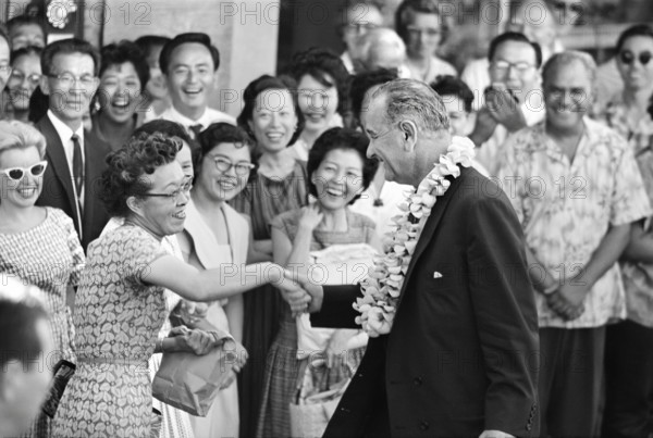 U.S. Vice President Lyndon B. Johnson wearing a lei and shaking a woman's hand, during an overnight stop in Honolulu, Hawaii, USA, Warren K. Leffler, U.S. News & World Report Magazine Photograph Collection, May 19, 1961