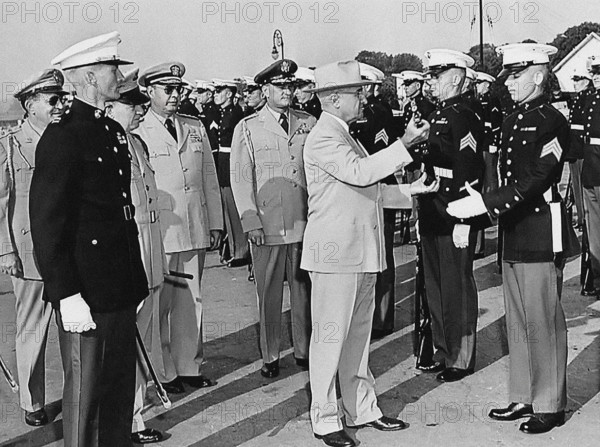 U.S. President Harry S. Truman inspecting rifle of unidentified Marine during visit to U. S. Marine Base. Also left to right: U.S. General Harry H. Vaughan (background), U.S. Admiral Robert L. Dennison and U.S. General Robert B. Landry, Quantico, Virginia, USA, Abbie Rowe, National Parks Service, Harry S. Truman Library, June 15, 1950