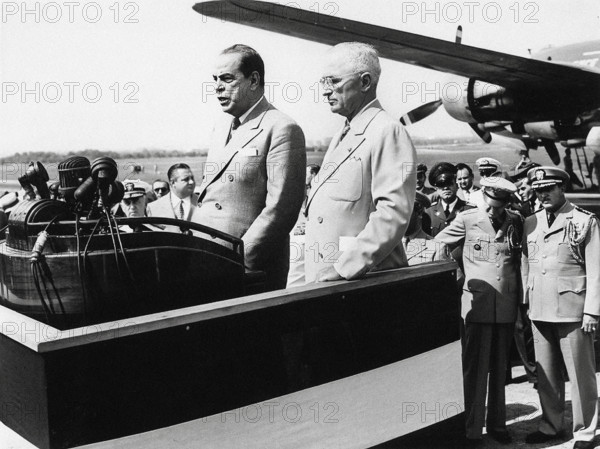 U.S. President Harry S. Truman (center-right) standing beside Romulo Gallegos (center-left), President of Venezuela, as he speaks at National Airport, Washington, D.C., USA, Abbie Rowe, National Parks Service, Harry S. Truman Library, July 1, 1948