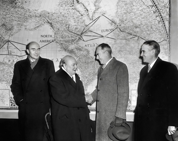 British Prime Minister Winston Churchill (left center) shaking hands with U.S. Secretary of State Dean Acheson (right center) in front of  large map of world as Director of Mutual Security Agency, W. Averell Harriman (right) and unidentified man look on, Washington, D.C., USA, Abbie Rowe, National Parks Service, Harry S. Truman Library, January 8, 1953
