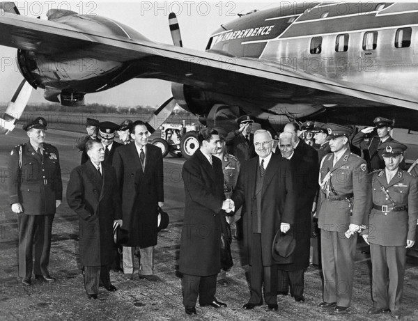 U.S. President Harry S. Truman (foreground, right) and the Shah of Iran Reza Pahlavi (foreground, left) shaking hands upon Shah's arrival in the United States, with the President's airplane, "The Independence" (which had brought the Shah to Washington) in the background, Washington National Airport, Washington, D.C., USA, Abbie Rowe, National Parks Service, Harry S. Truman Library, November 16, 1949
