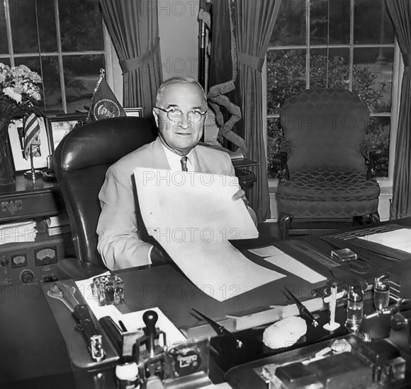 U.S. President Harry S. Truman displaying the National Security Act Amendments of 1949, which he had just signed at his desk in the White House oval office, Washington, D.C., USA, Abbie Rowe, National Parks Service, Harry S. Truman Library, August 10, 1949