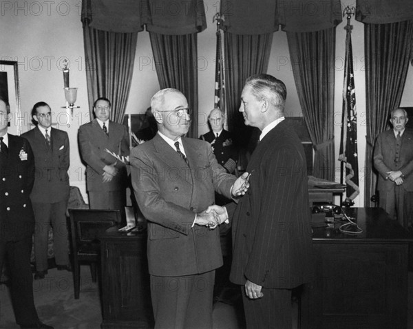 U.S. President Harry S. Truman (left) presenting Medal of Merit to U.S. Secretary of Defense James Forrestal (right) in the White House Oval Office, Washington, D.C., USA, Abbie Rowe, National Parks Service, Harry S. Truman Library, January 27, 1948