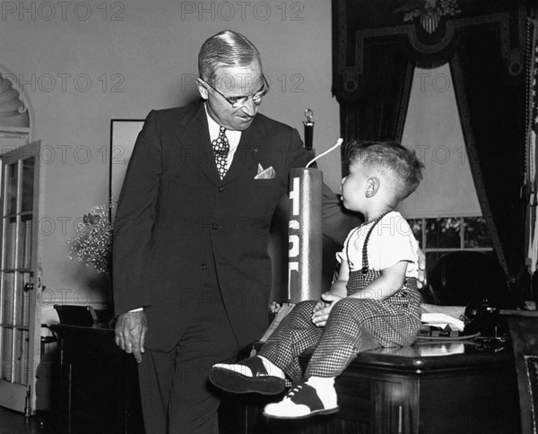 U.S. President Harry S. Truman chatting with Michael Dene Condatore in the White House Oval Office after the young boy presented a "firecracker" and tickets to the American Cavalcade of Freedom to the President, which will be held on July 4 at the grounds of the Washington Monument, Washington, D.C., USA, Abbie Rowe, National Parks Service, Harry S. Truman Library, June 24, 1947