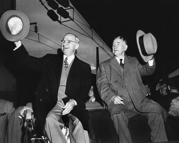 U.S. President Harry S. Truman (left) and U.S. Vice President-elect Alben W. Barkley (right) sitting on the back of an open vehicle at train station upon their return, waving their hats to the crowd after winning the 1948 election, Washington, D.C., USA, Abbie Rowe, National Parks Service, Harry S. Truman Library, November 5, 1948