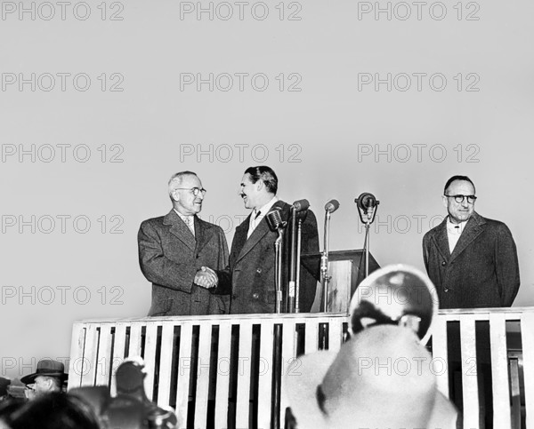 U.S. President Harry S. Truman (left) and President Carlos Prio Socarras of Cuba (second from left) shaking hands on platform upon President Prio Socarras' arrival at National Airport, Washington, D.C., USA, Abbie Rowe, National Parks Service, Harry S. Truman Library, December 8, 1948