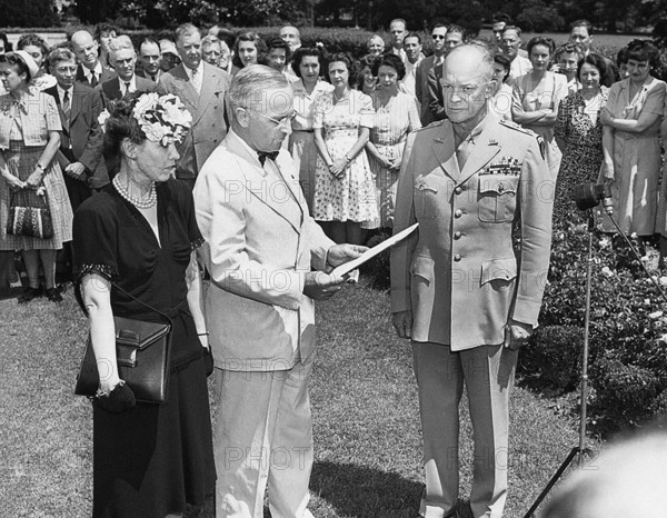 U.S. President Harry S. Truman (center) reading citation for U.S. General Dwight D. Eisenhower's Distinguished Service Medal, while the General (right) and his wife Mamie Eisenhower (left) look on, Washington, D.C., USA, Abbie Rowe, National Parks Service, Harry S. Truman Library, June 18, 1945