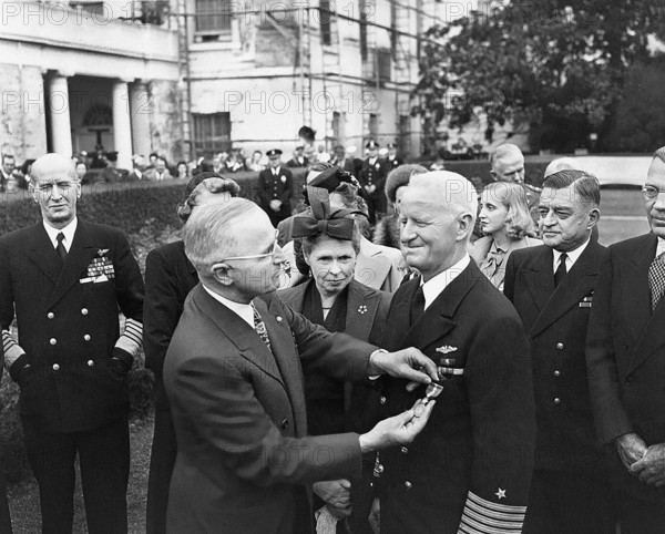 U.S. President Harry S. Truman (left foreground) giving U.S. Admiral Chester Nimitz (right foreground) a Gold Star (in lieu of a third Distinguished Service Medal) with Mrs. Catherine Nimitz (between Truman and Nimitz), Margaret Truman (third from right, background), and several unidentified people looking on, White House Rose Garden, Washington, D.C., USA, Abbie Rowe, National Parks Service, Harry S. Truman Library, October 5, 1945
