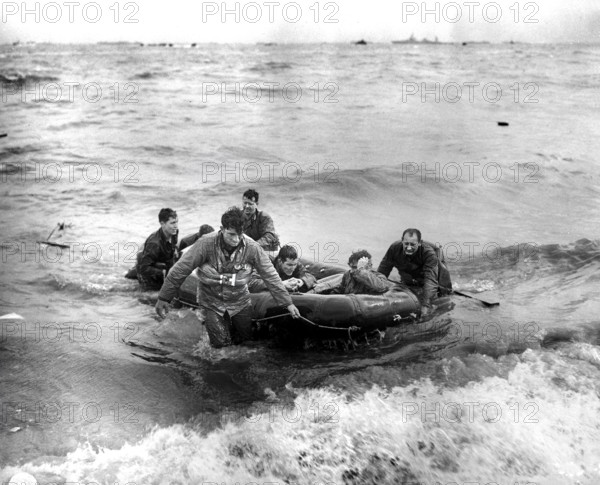 Survivors of sunken LCVP off coast come safely ashore in rubber life raft, Omaha beach, Cherbourg Area, France, Weintraub, U.S. Army Signal Corps, June 6, 1944